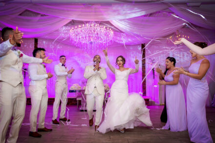 bride and groom walking between bridal party shooting streamers at the crystal ballroom tampa with pink uplighting