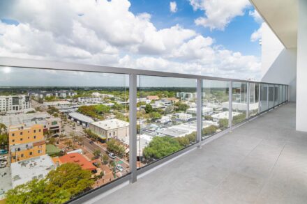 glass balcony railing with sarasota downtown and blue sky and cloud background