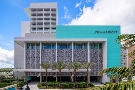 front of jw marriot clearwater beach with palm trees in foreground and blue paneling on side