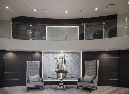gorgeous condominium lobby with glass rail, high backed chairs and a large orchid plant on a table