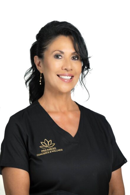 white studio headshot of smiling brunette woman in black scrubs with a medical spa logo