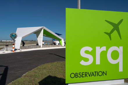 srq airport observation lime green sign with wing structure in background