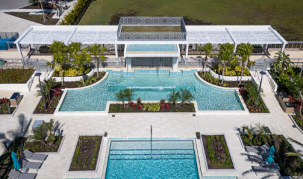 aerial view of a pool with a waterfall and tropical landscaping