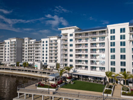 aerial view of a large hotel on the water with aluminum balcony railing
