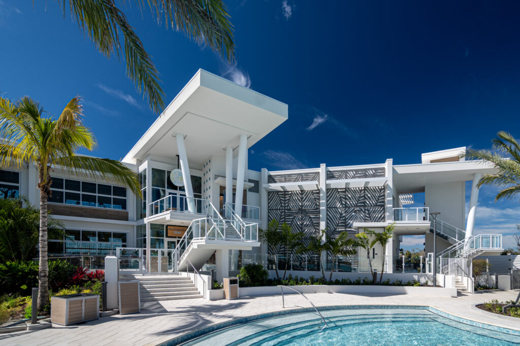 Multiple story modern white architecture with glass railing and brown organic designed decorative aluminum wall facades