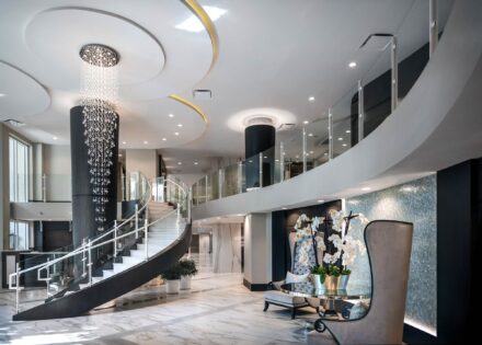 interior photograph of luxury Seaglass condominium's lobby with a floating staircase and cat walk with glass railing