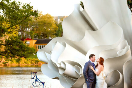 bride and groom embracing in front of art sculpture at Mennello art museum