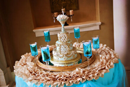 elegant wedding cake in gold and baby blue with floating candles