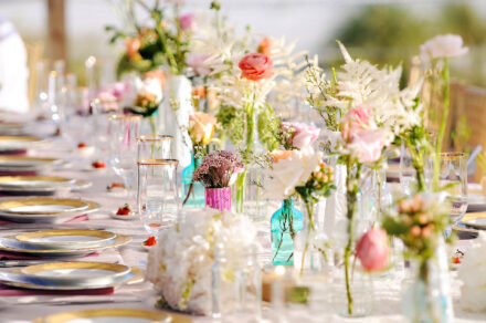 Gorgeous reception dinner table set up with dainty flowers in glass vases