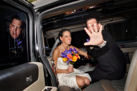 bride groom in limo fighting off fake paparazzi by holding hand out to camera with reflection of his angry face showing in window